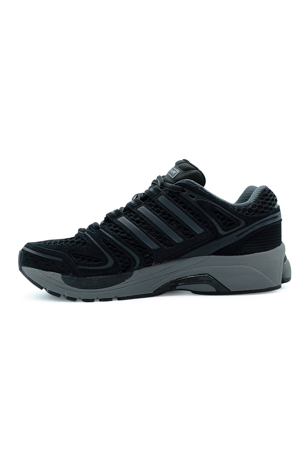 Medial arch view of the Adidas Adistar Control 5 shoe in black and grey, detailing the structured arch support shank, breathable mesh quarter panel, tonal nubuck Three Stripes, and supportive sculpted Grey Six EVA foam midsole.