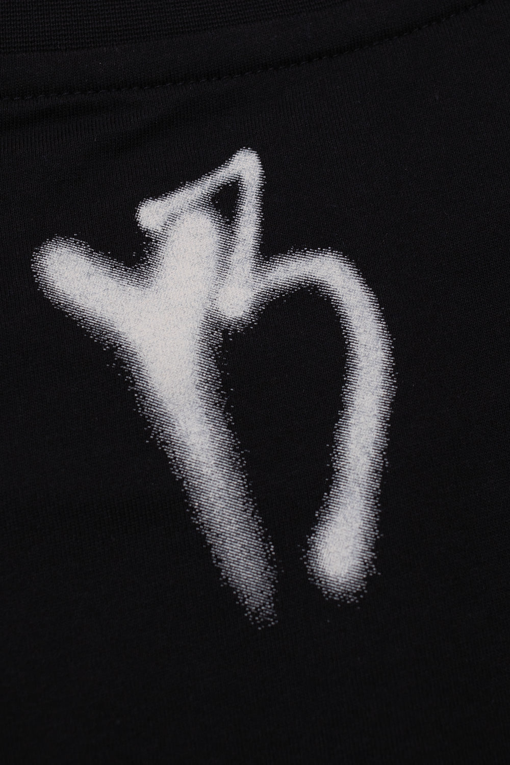 Close-up view of the back neckline on the black Adidas Y-3 X Chito GFX Graphic Tee, showing the white spray-paint stencil style Y-3 logo printed below the ribbed collar seam.
