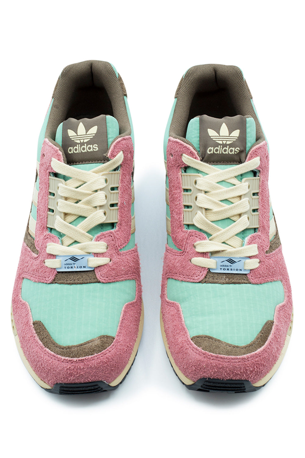 Top-down studio view of a pair of Adidas ZX 8000 running shoes, displaying the seafoam green grid ripstop toe boxes with olive suede inserts, textured pink hairy suede mudguards, cream flat laces, beige Ghilly lacing stays, light blue "adidas TORSION" dubraes, and brown padded textile tongues with white Trefoil logo tags