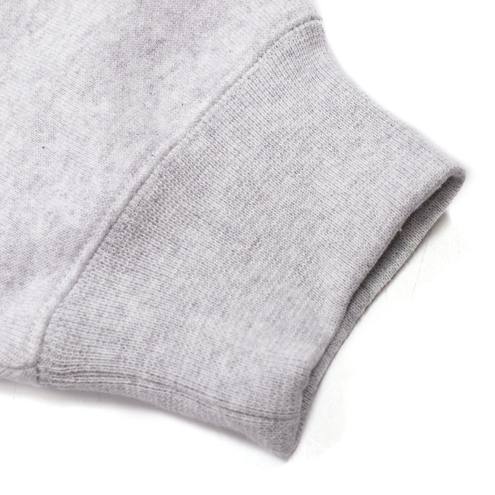Macro studio close-up of the sleeve cuff on the BoTT Script Logo Hoodie in Ash, detailing the thick, stretchy ribbed knit wrist band seamlessly attached to the soft, heathered light grey cotton-poly fleece fabric with reinforced overlock stitching.