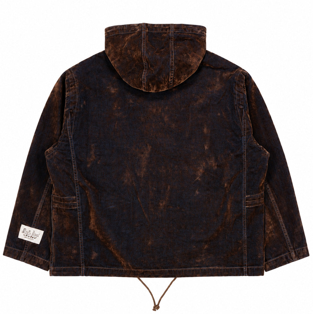 Back flat lay studio perspective of the Brain Dead Flocked Denim Fireman Jacket, displaying the spacious three-panel hood lying flat across the shoulders, straight back yoke with clean vertical seam lines, hanging bottom hem cinch cord, and a white rectangular woven Brain Dead California Designs brand label sewn on the lower left sleeve.