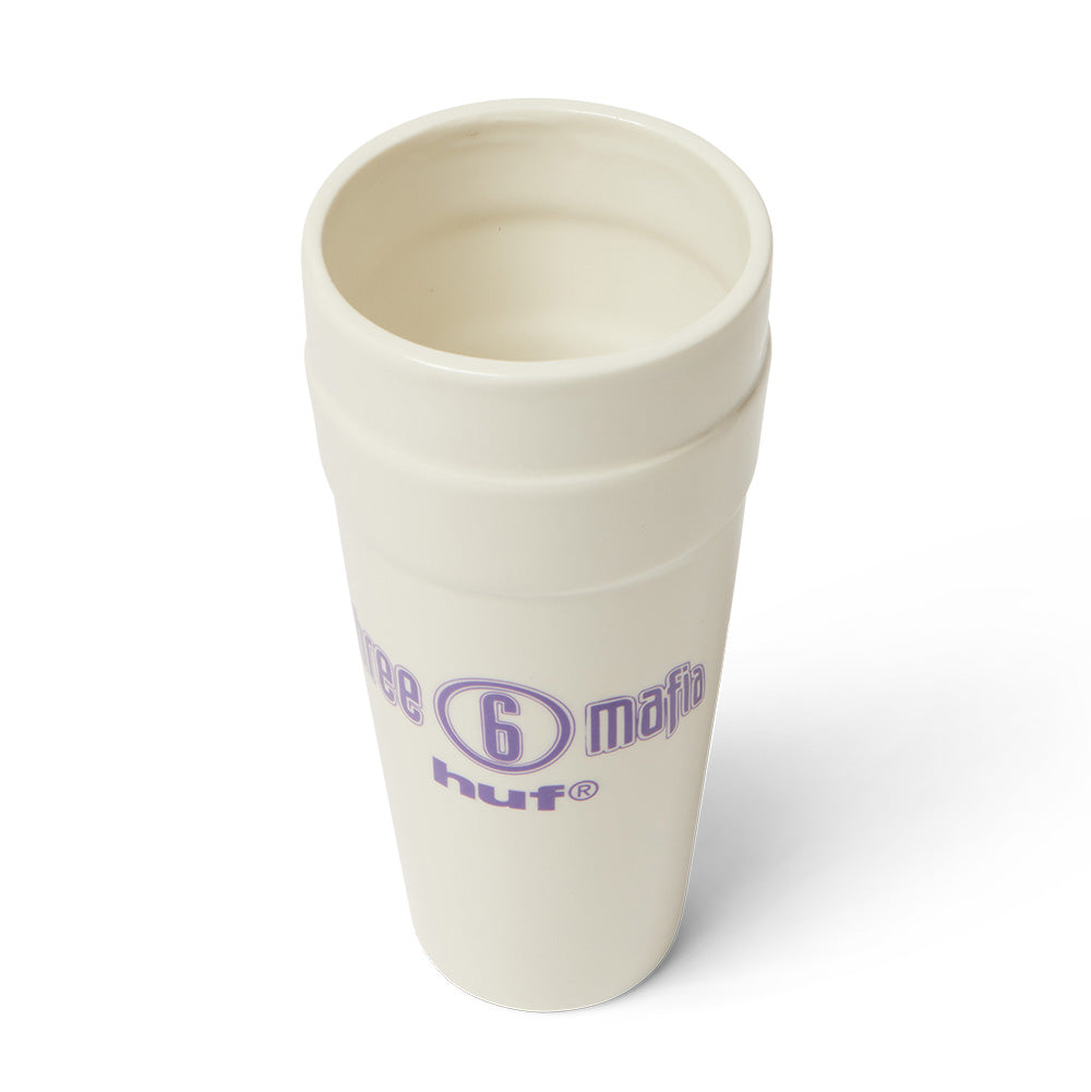 High-angle studio perspective looking into the interior opening of the Huf X Three 6 Mafia Ceramic Double Cup, highlighting the smooth off-white glazed ceramic rim, deep drink opening, ridged stacked cup exterior detailing, and side-facing purple collaborative logo print.