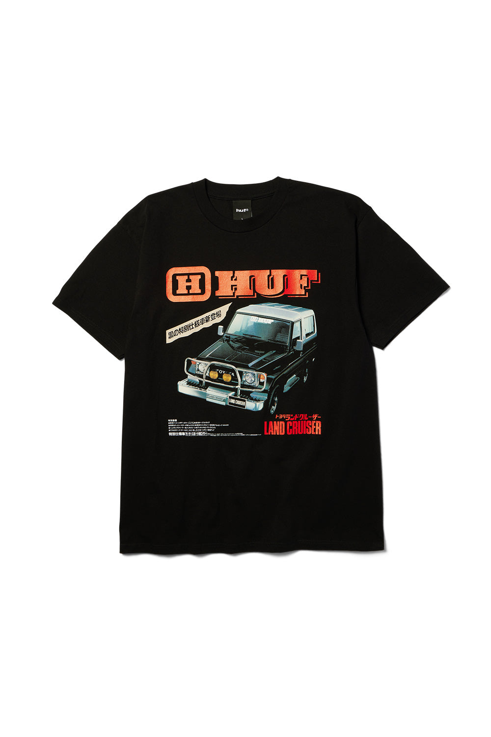 Front flat lay view of the black Huf X Toyota Land Cruiser Turbo SS T-Shirt made from 200g cotton fabric, showcasing a large retro Japanese magazine ad graphic across the chest featuring an illustrated dark metallic grey Toyota Land Cruiser 70 Turbo with chrome bull bar and yellow fog lights, set beneath bold orange-red gradient HUF block lettering and Japanese Katakana typography.