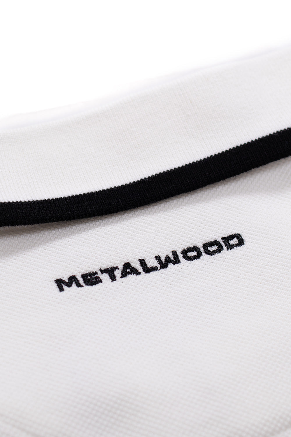 Metalwood Studio World Class Zip Polo White – elegante Mischung aus Golf- und Skate-Inspiration mit weichem Baumwoll-Piqué und einzigartigem Sticklogo.