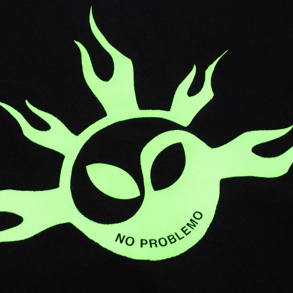 Detailed macro studio close-up of the front chest graphic on the black Aries No Problemo No Yang T-Shirt, highlighting the sharp, high-opacity neon lime-green screen-printed ink displaying the flaming tribal sunburst rays, almond-shaped alien eyes within the Yin-Yang swirl, and uppercase "NO PROBLEMO" curved text against the black cotton fabric.