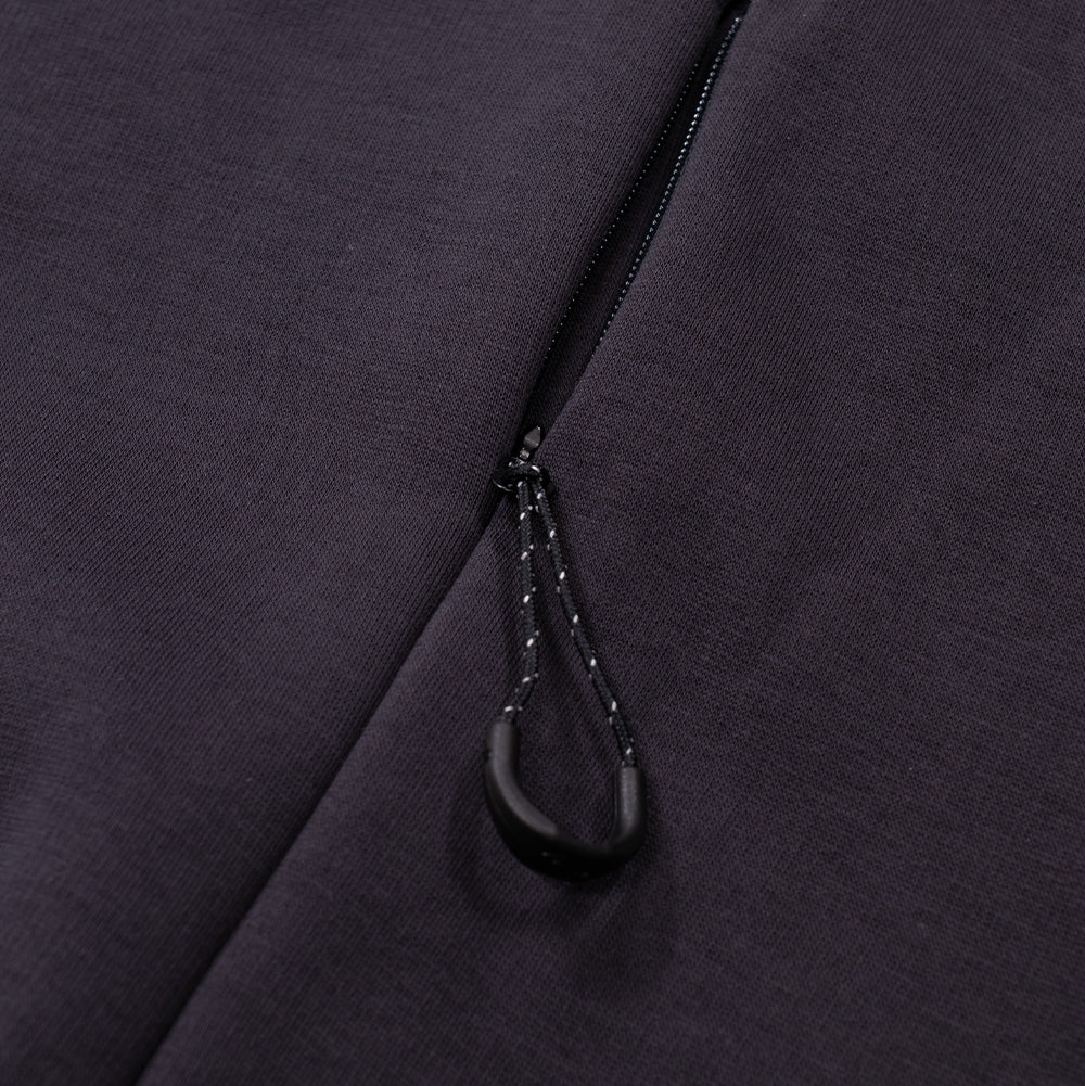 Detailed macro perspective of the side waist utility pocket on the Oakley FGL Slick Fleece Hoodie, displaying the sleek concealed reverse-coil zipper track built into the side seam, equipped with a reflective-flecked paracord pull loop and curved ergonomic black grip.