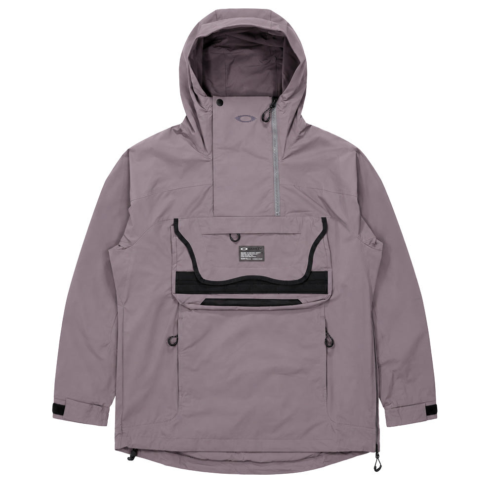 Front flat lay studio view of the Oakley FGL Stroke Anorak 6.7 in Gray Wash, showcasing a technical outdoor pullover windbreaker in washed mauve-grey, featuring a high-neck storm hood with asymmetrical zipper and snap closure, a large modular front cargo pocket trimmed with black webbing gear loops and utility spec patch, lower zip hand pockets, adjustable velcro cuffs, and a side entry zip with hem drawstrings.