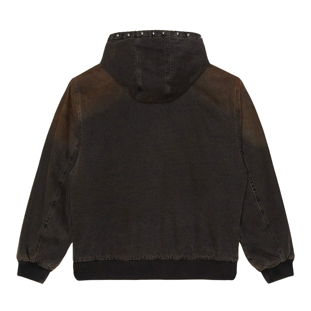 Back flat lay view of the Obey Studded Zip Up Jacket in black rust wash, showing the washed cotton canvas shell with distinct faded rust-brown fading across the shoulders and hood, wide-cut sleeves, thick ribbed hem, and a line of round metal domed studs along the back rim of the hood.