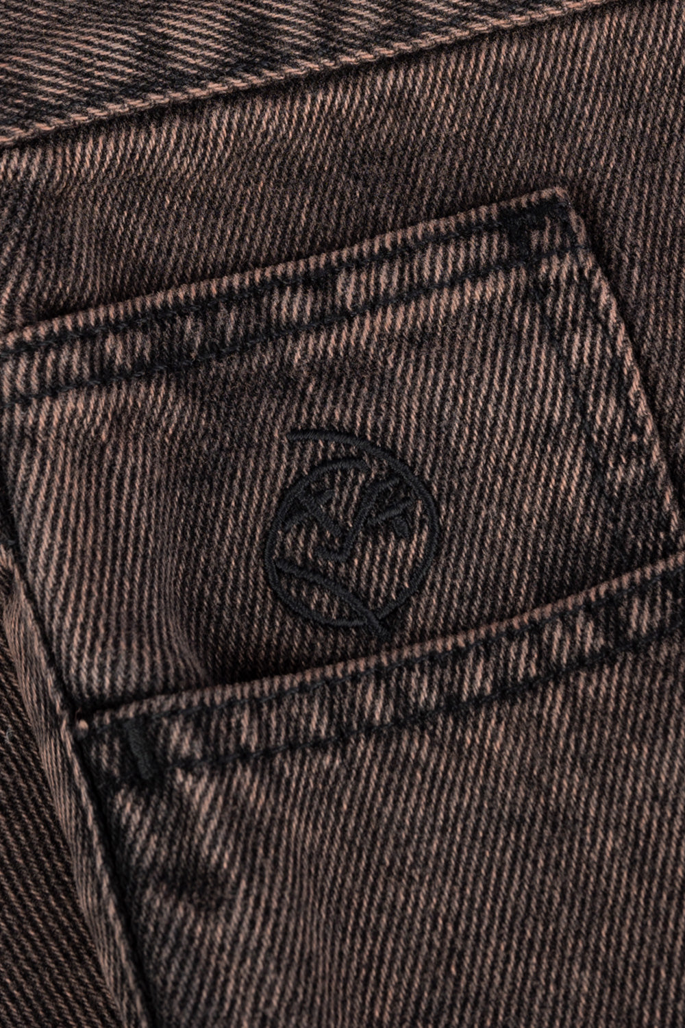 Detailansicht des Logos auf den Polar Skate Co. Big Boy Shorts in Mud Brown