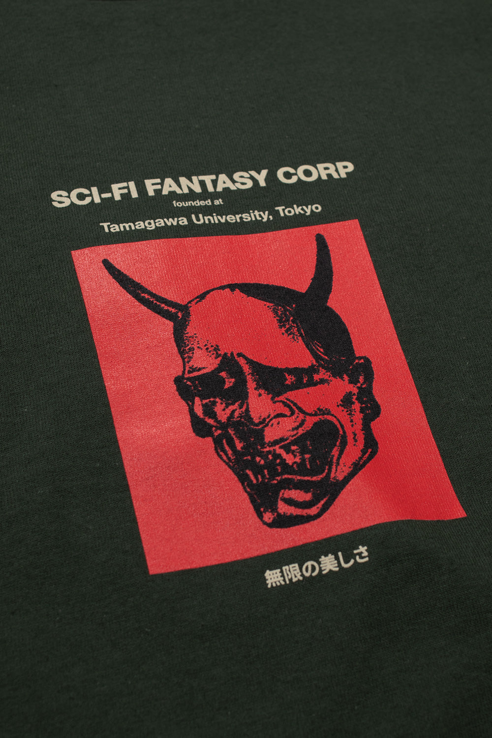 Detailaufnahme des roten "Tamagawa U"-Designs auf der Vorderseite des grünen Sci-Fi Fantasy T-Shirts