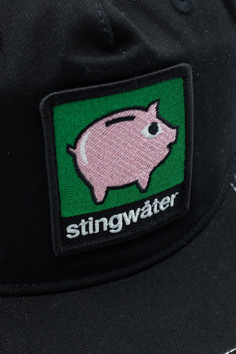 Stingwater Piggy Bank Trucker Cap Black – Trendige schwarze Trucker Cap von Stingwater mit Piggy Bank Patch für ein cooles, urbanes Design