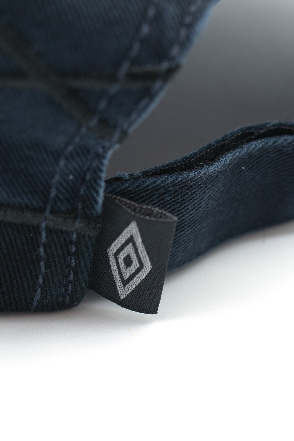 Detailed fabric texture and stitching on Umbro Collision baseball cap, showcasing British sportswear heritage and modern street style
