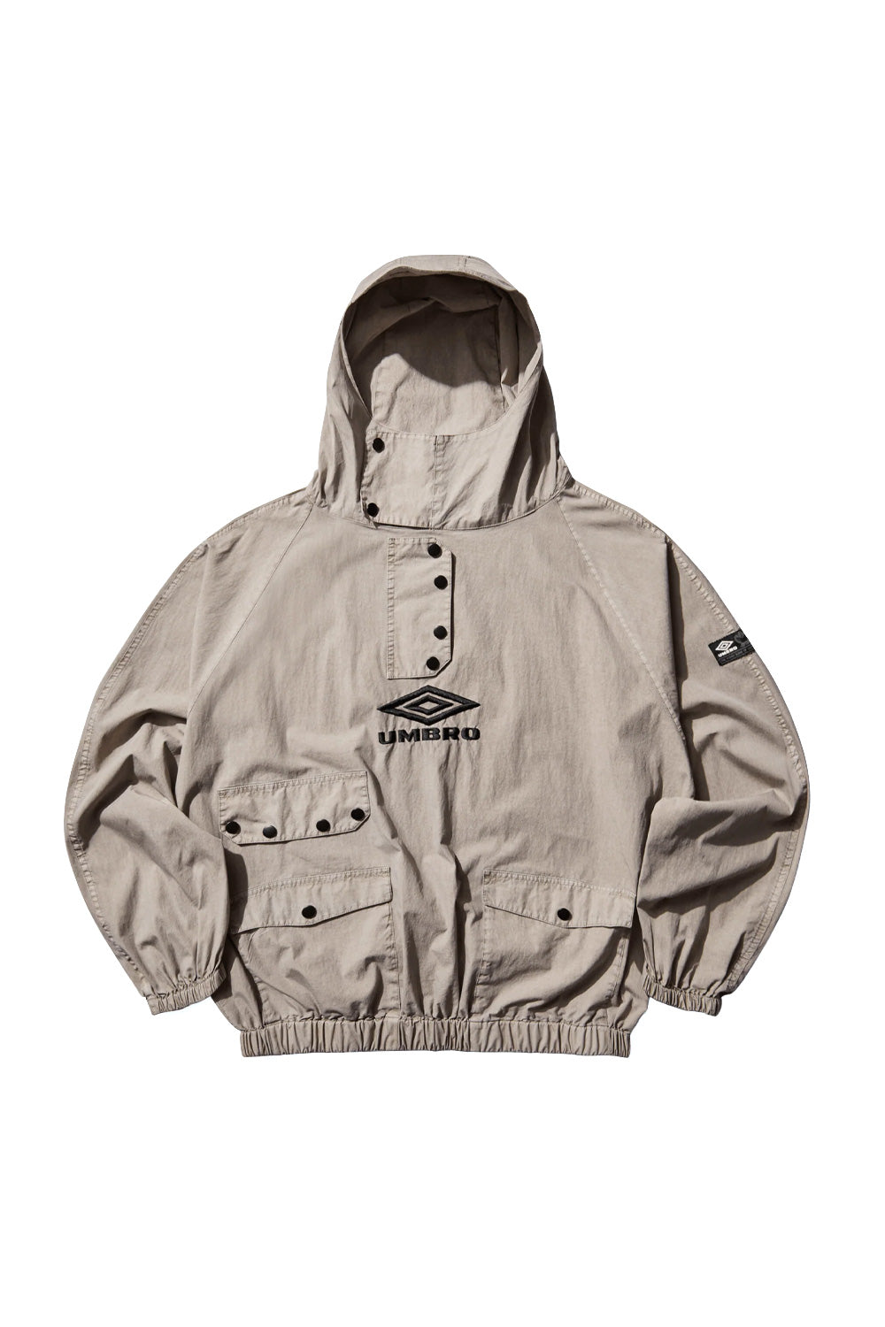 Front view of Umbro Faded Smock Anorak in greige featuring snap button placket, four flap pockets and loose boxy silhouette