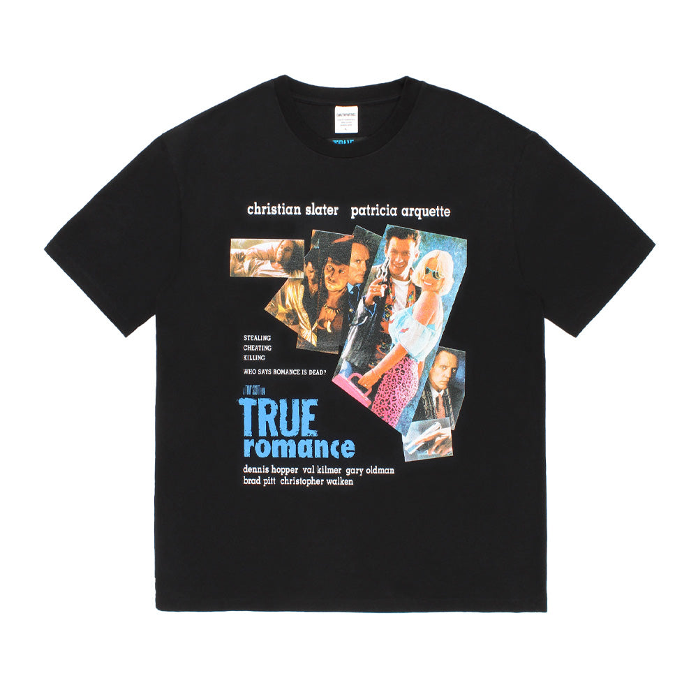 Front flat lay studio view of the Wacko Maria x True Romance Washed Heavy Weight Crew Neck T-Shirt Type 1 in washed black, showcasing a relaxed boxy cut, ribbed crew neckline, and a large multi-colored movie poster graphic print featuring Christian Slater, Patricia Arquette, and the cast alongside bold blue True Romance typography.