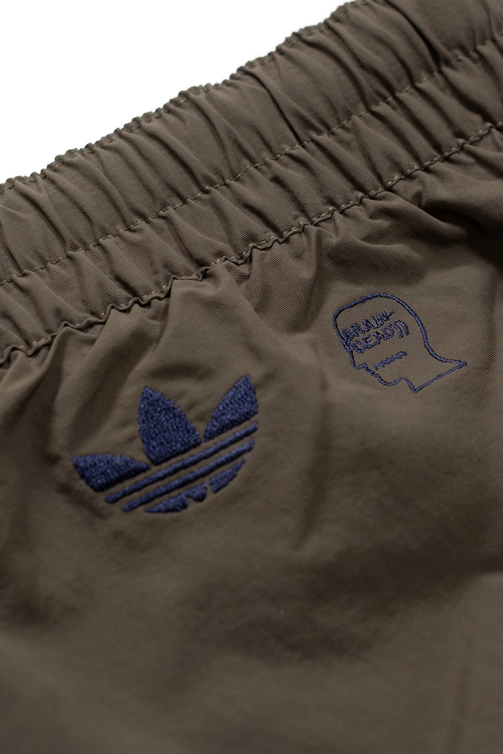 Close-up des Beinmotivs der Adidas x Brain Dead Shorts – sportlich, unkonventionell und kreativ zugleich.