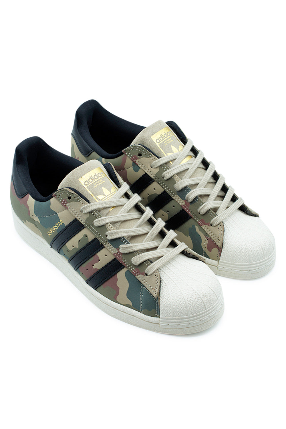 Three-quarter perspective of the adidas Superstar ADV skate shoes highlighting the military-inspired camouflage leather upper, premium black leather Three Stripes, gold Superstar branding, legendary shell toe and timeless adidas Originals heritage.