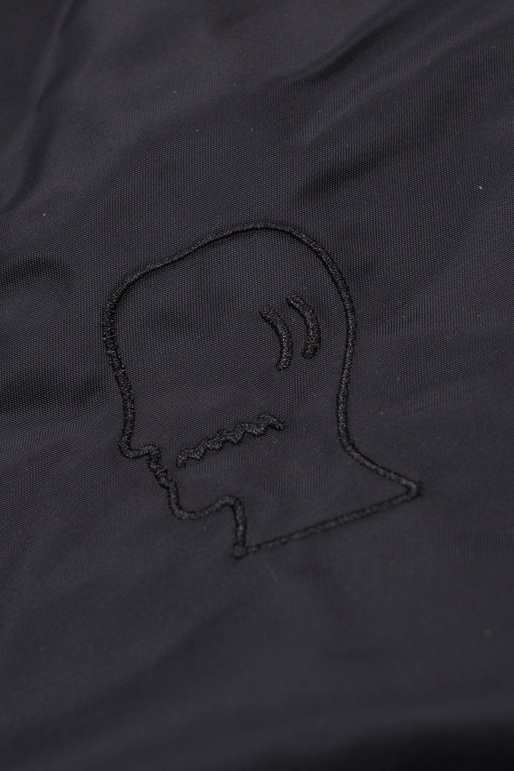 High-quality Brain Dead Embroidered 3D Flight Jacket Black, streetwear nylon bomber with bold logohead embroidery and quilted orange interior.