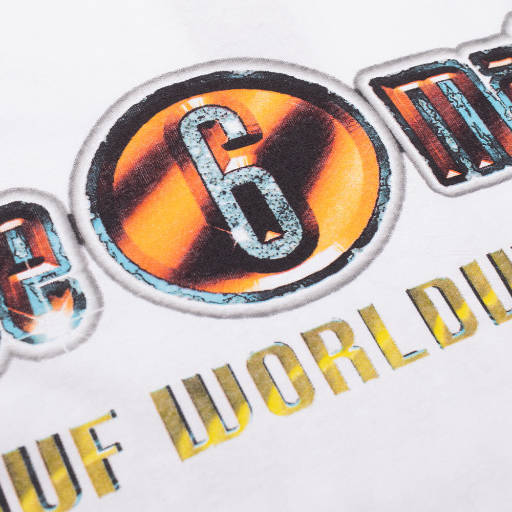 Studio macro perspective of the back graphic print on the Huf X Three 6 Mafia Smoke Clears T-Shirt, focusing on the heavy vintage airbrush styling of the metallic "6" disc badge, crackled chrome textures, and yellow distressed "HUF WORLDWIDE" lettering.