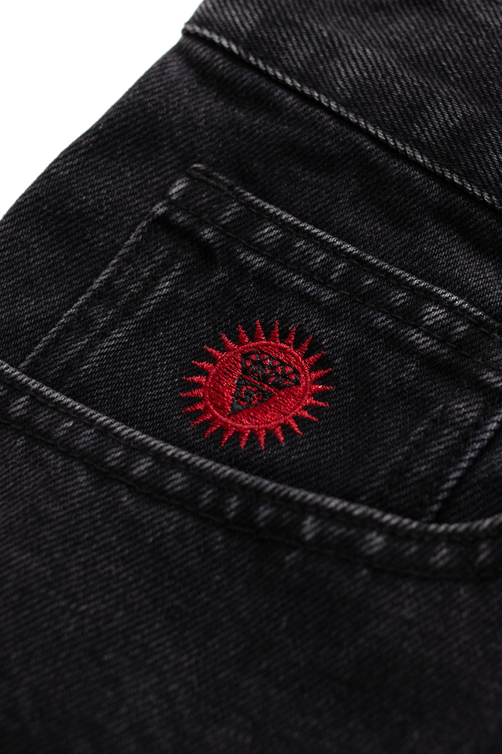 Detailansicht des Running Dog Prints in Blau auf schwarzem Denim – kreatives Signature-Motiv von IceCream.