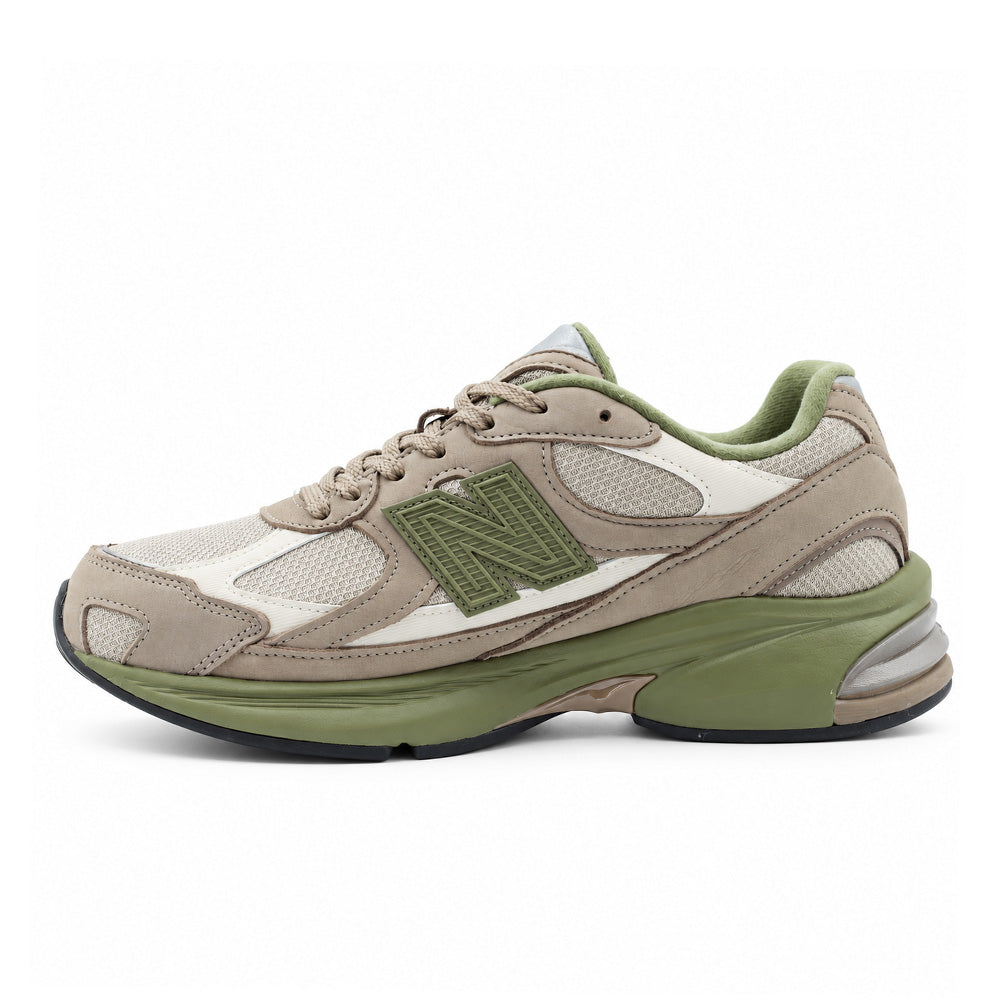 Medial side studio view of the New Balance 2010 (GORE-TEX) sneaker in Mushroom Timberwolf, emphasizing the arch support geometry, ribbed olive green N logo panel, smooth transition from light tan nubuck to structured mesh, and the sculpted two-tone ABZORB foam midsole.