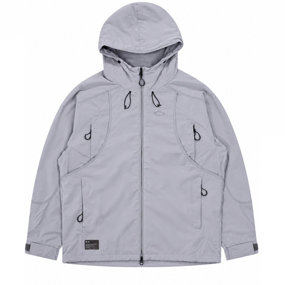 Front flat lay studio view of the Oakley FGL Sector Jacket 6.7 in Winter Grey, showcasing an outdoor technical hooded shell jacket crafted from matte, water-repellent hybrid fabric with a soft peached finish, featuring a high-neck adjustable hood with bungee drawcords, full two-way front zipper, four seamless curved utility zipper pockets with cord pull tabs, adjustable velcro cuff tabs, and a dark woven military-spec Oakley FGL patch on the lower right hem.