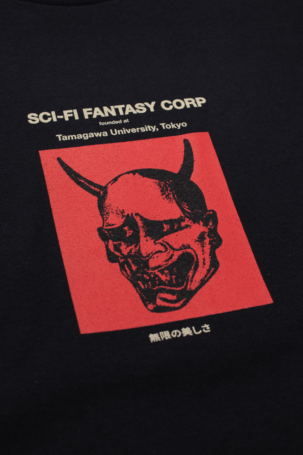Detailaufnahme des roten "Tamagawa U"-Designs auf der Vorderseite des schwarzen Sci-Fi Fantasy T-Shirts