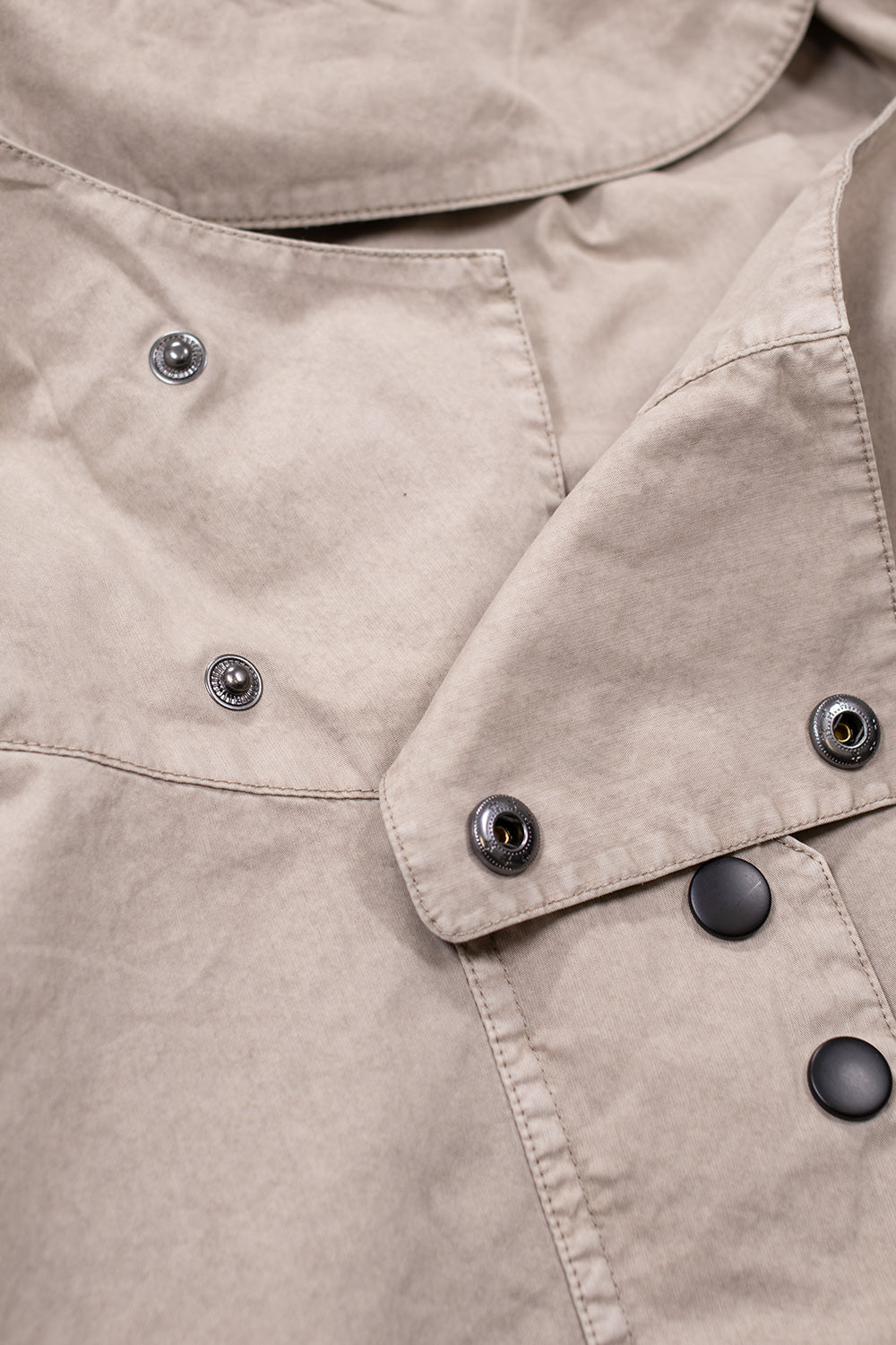 Detail of snap button hood and front closure on Umbro Faded Smock Anorak Greige street style jacket