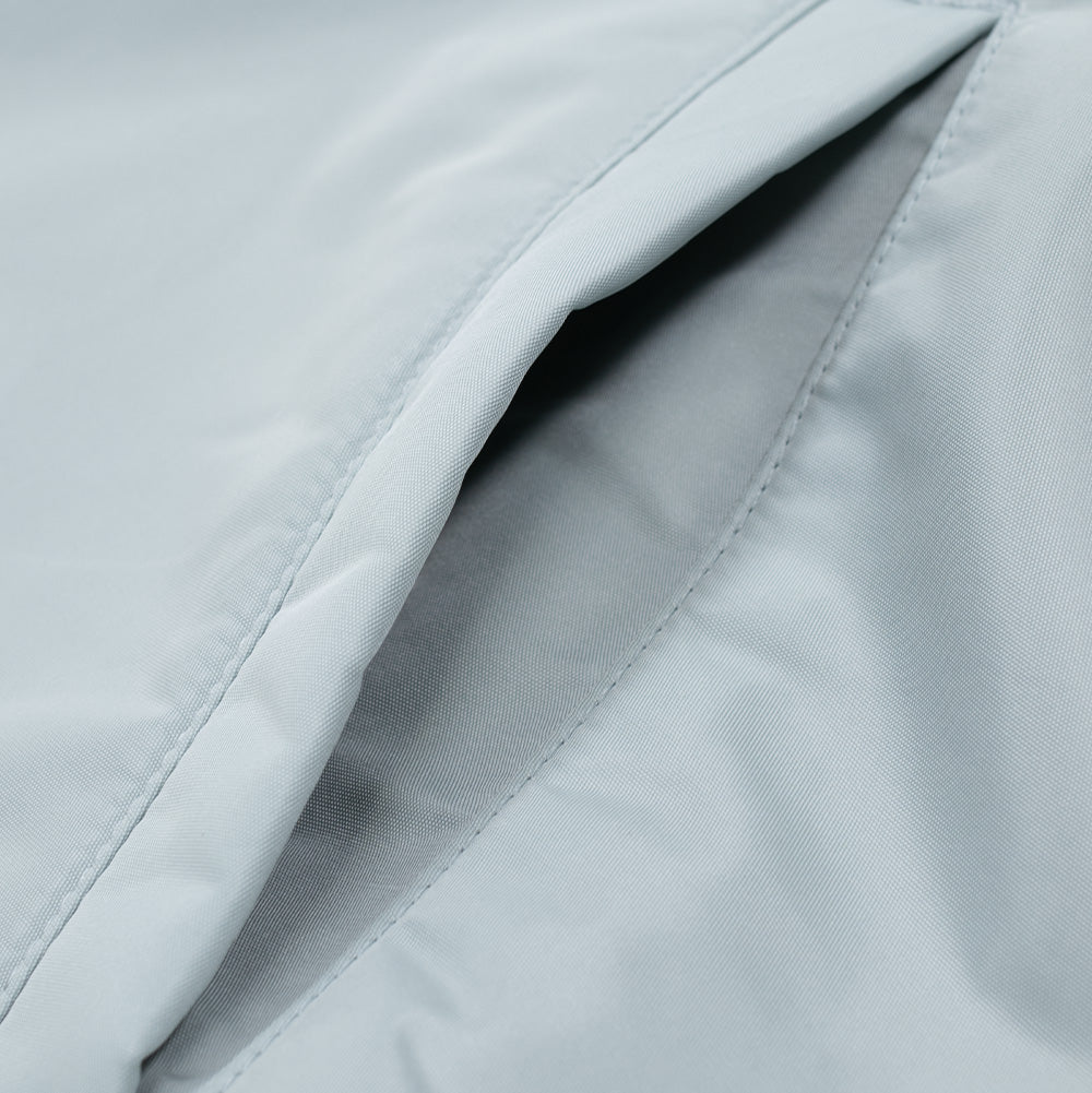 Macro studio perspective of the diagonal side pocket on the Wacko Maria Coach Jacket, detailing the reinforced welt edge opening, precise tonal topstitching, and soft internal grey pocket lining.