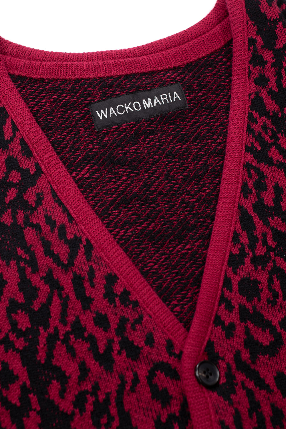 close up of Wacko Maria red leopard knit cardigan V-neck collar and label, showcasing high quality cotton wool blend and detailed jacquard construction
