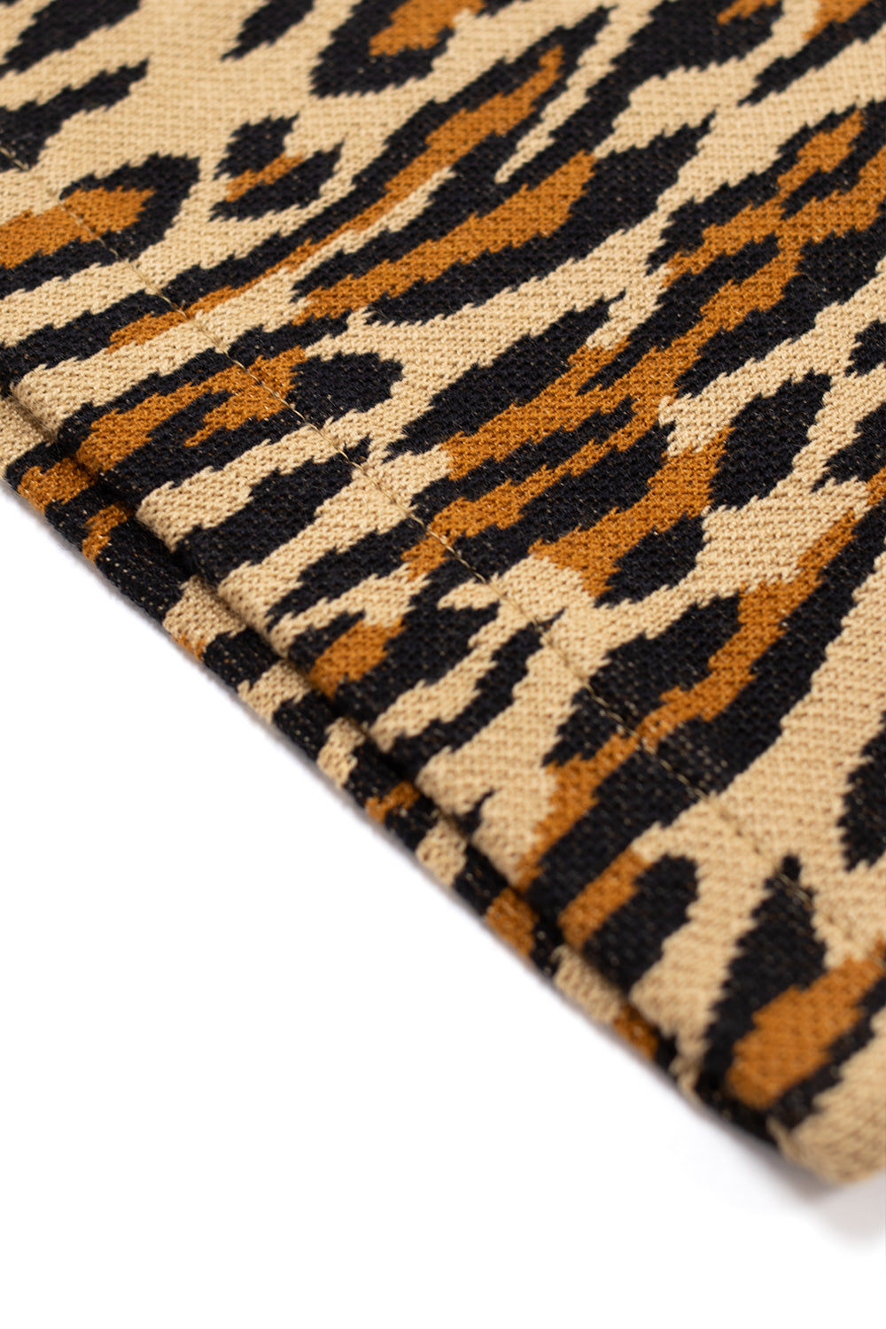 detailed view of ribbed hem and sleeve finish on Wacko Maria leopard knit polo, highlighting structured cotton knit, all over animal pattern and high-end Japanese production