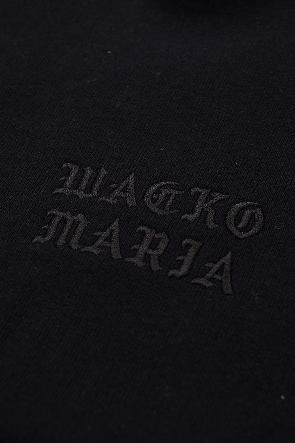 Wacko Maria embroidered logo detail on black heavy weight hoodie, subtle tonal branding on luxury Japanese streetwear pullover