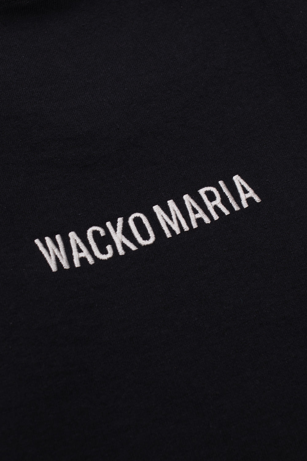 Detailed embroidery of Wacko Maria branding on back of black crew neck T-shirt, premium Japanese streetwear collaboration with Terrifier horror franchise