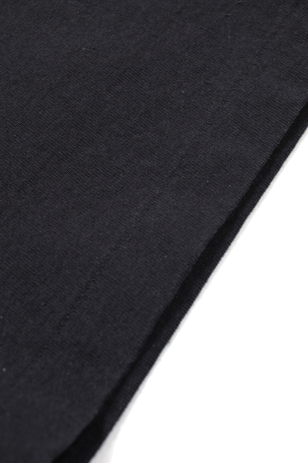 Macro detail of heavyweight cotton fabric and vintage single stitch hem on Wacko Maria x Terrifier Type-2 T-shirt, durable washed black tee high-quality construction